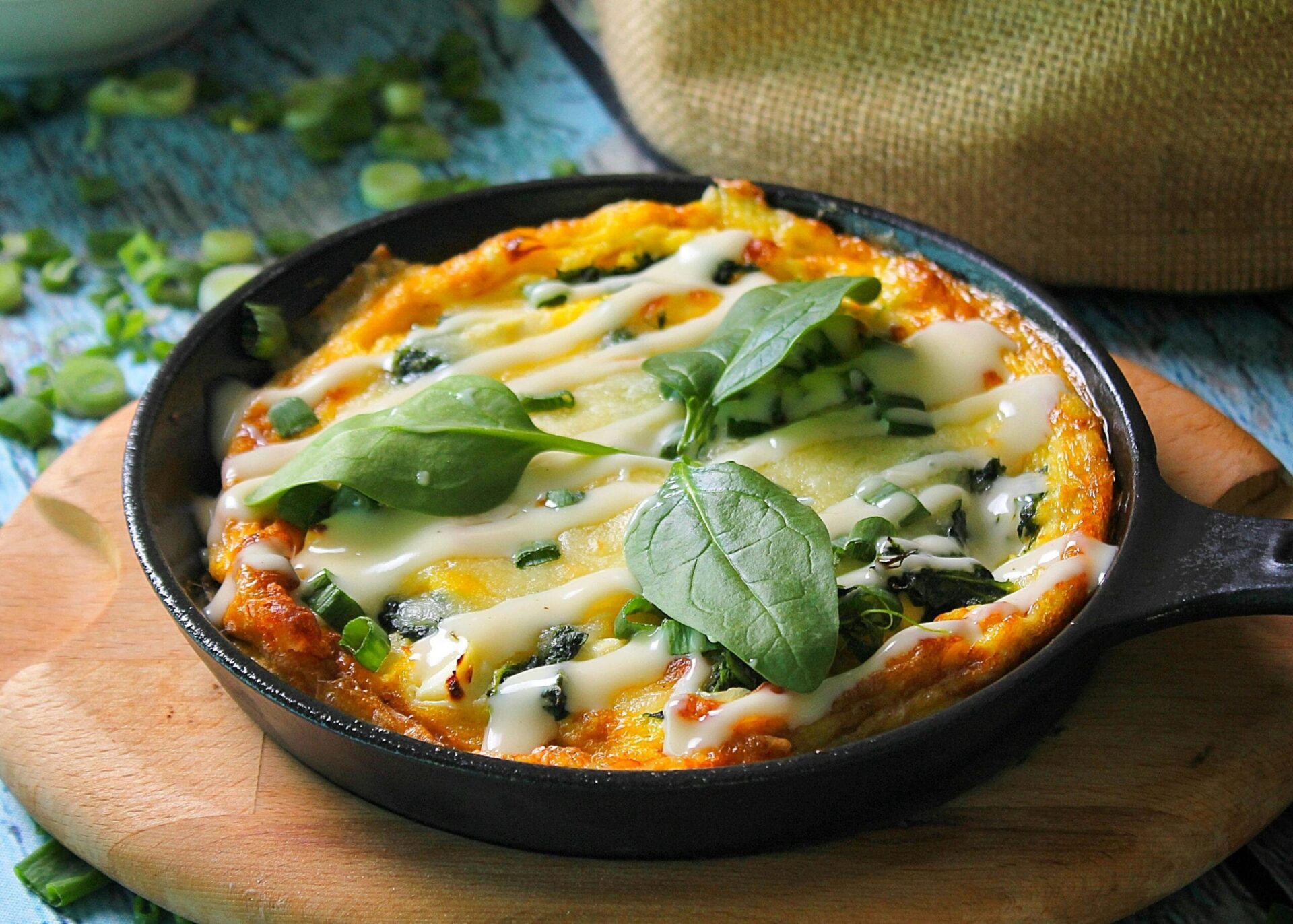 A slice of beef frittata showcasing layers of seasoned ground beef, eggs, and vegetables.