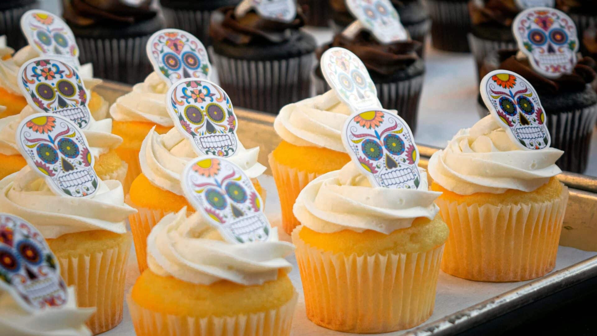 Festive Spooky Purple Skulls Cupcakes Recipes topped with colorful skull decorations, perfect for Halloween celebrations.
