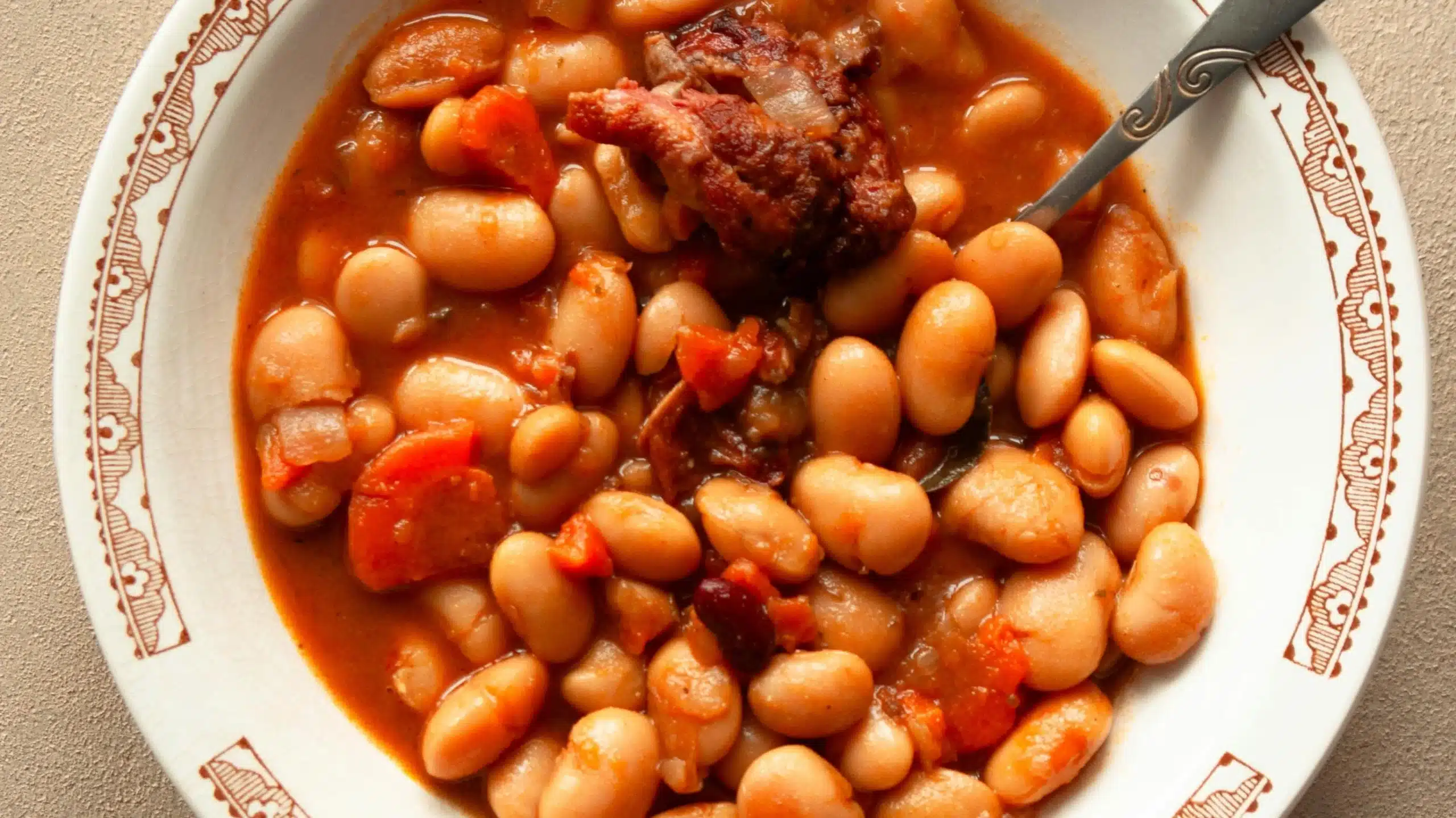 A hearty bowl of 15 bean soup slow cooker style, featuring tender beans, rich tomato broth, and flavorful chunks of meat.