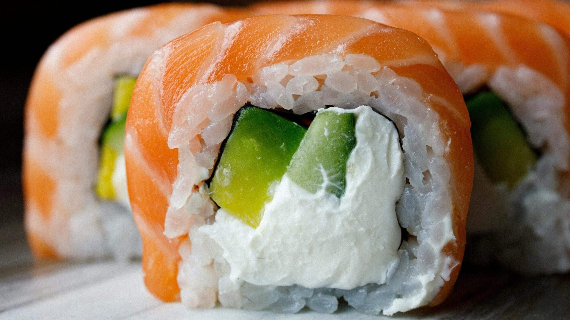 A close-up of Temaki Salmon Cream Cheese, featuring fresh salmon, creamy cheese, and avocado wrapped in sushi rice.